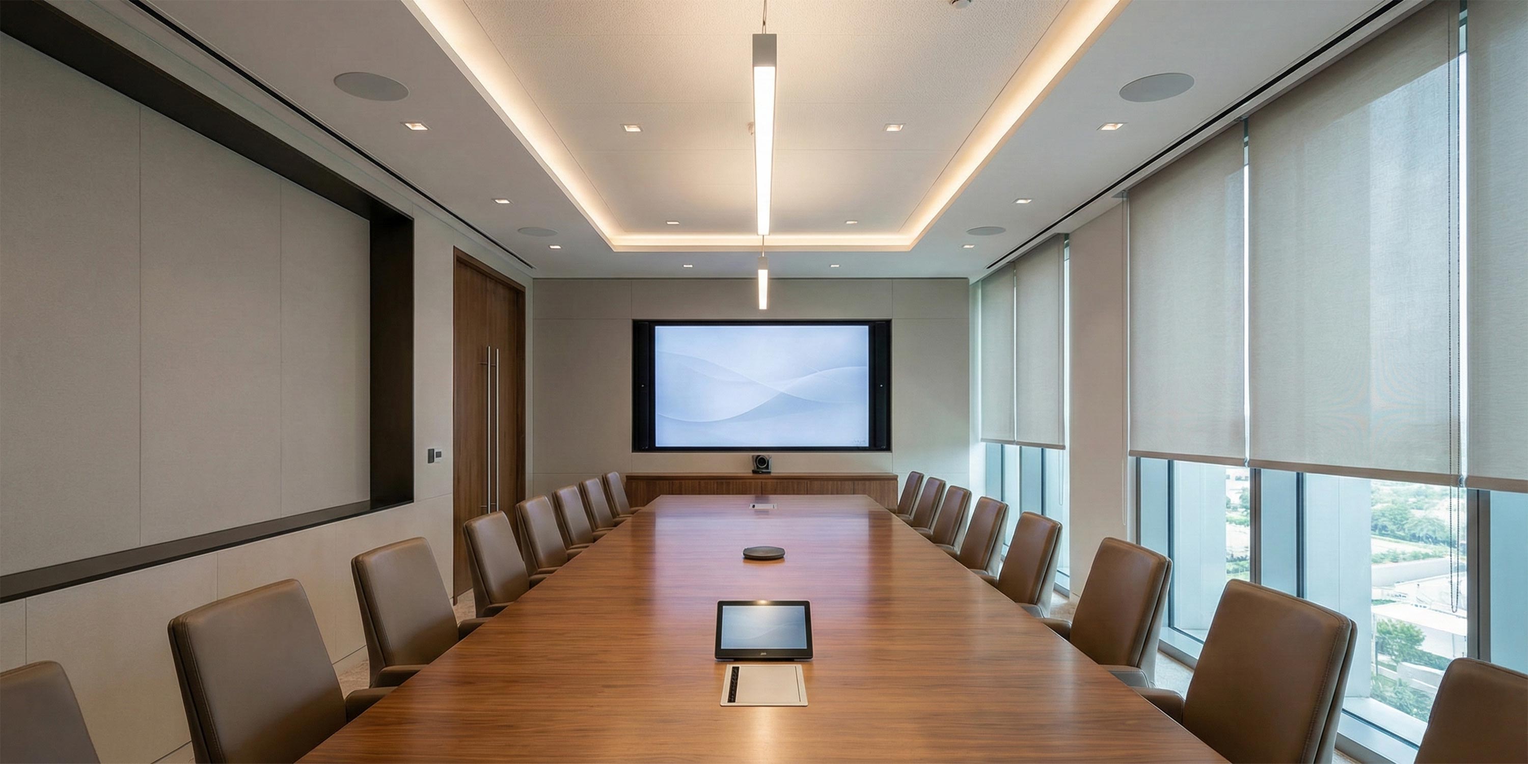 Modern executive conference room with long table, leather chairs, and large wall display