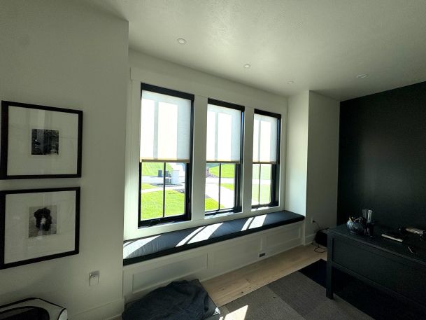 Office room bay window seat showing three individual window openings with partial shades