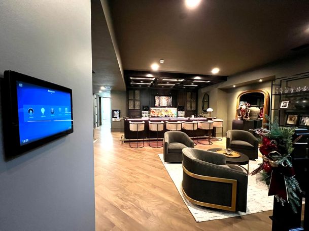 Intelligent control panel interface mounted on wall overlooking luxury home basement bar