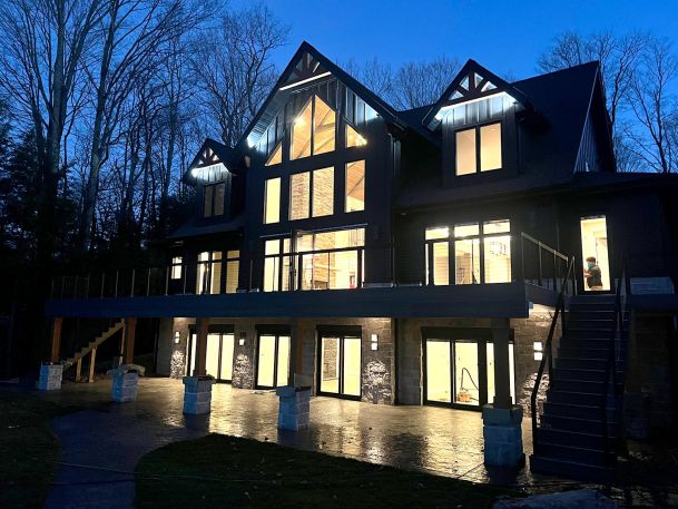Large contemporary house architecture illuminated at night showcasing massive lit windows