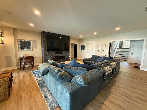 Basement living area showing a massive section sofa and fireplace media wall set up