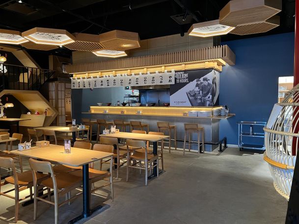 Empty dining room of a restaurant with wooden tables and custom hexagon ceiling lights