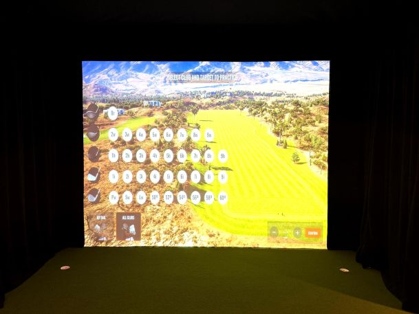 Golf simulator screen displaying digital club selection menu on green fairway
