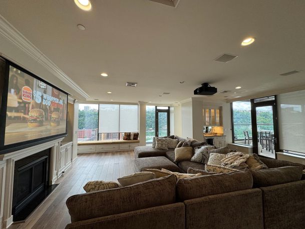 Finished basement living area showing large drop down screen system displaying media