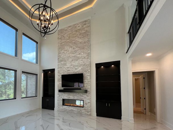 Modern white living room with high ceiling showing large sphere chandelier and fireplace